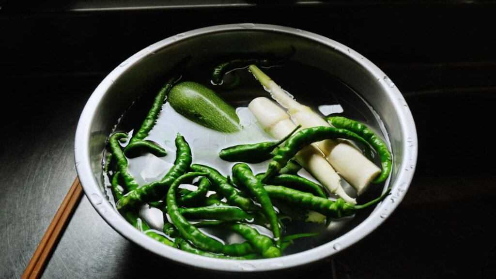 Food particles and debris floating in a backed-up sink, showing common culprits of clogs.

