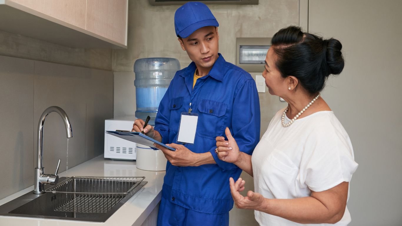 A Tubero Experts plumber reassuring a stressed client about a plumbing emergency, demonstrating empathy and expertise.