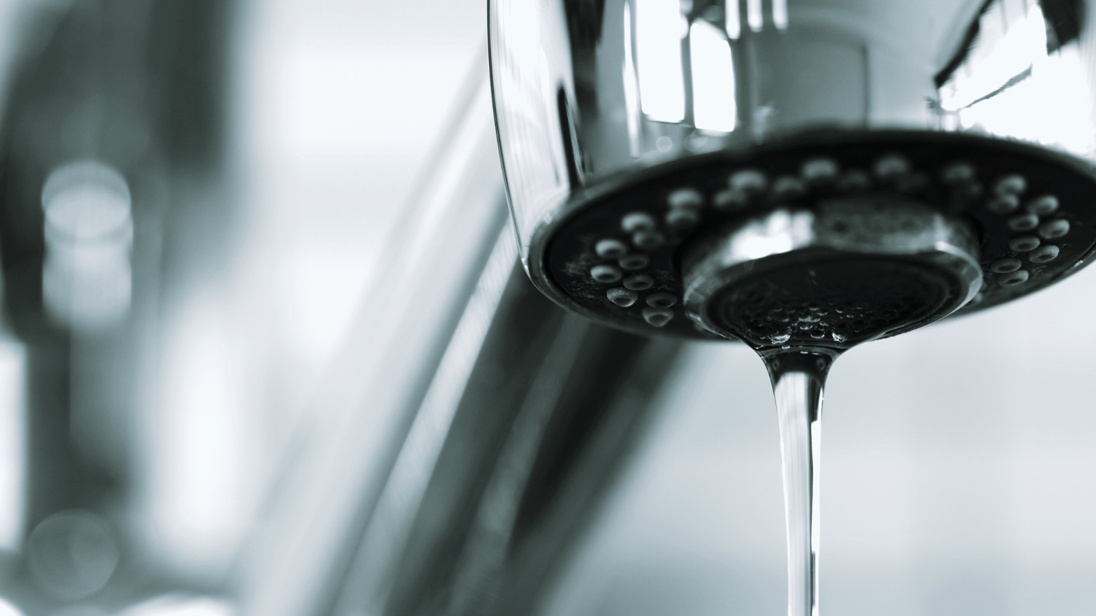 A steady drip of water from a kitchen faucet, highlighting a common household plumbing nuisance.
