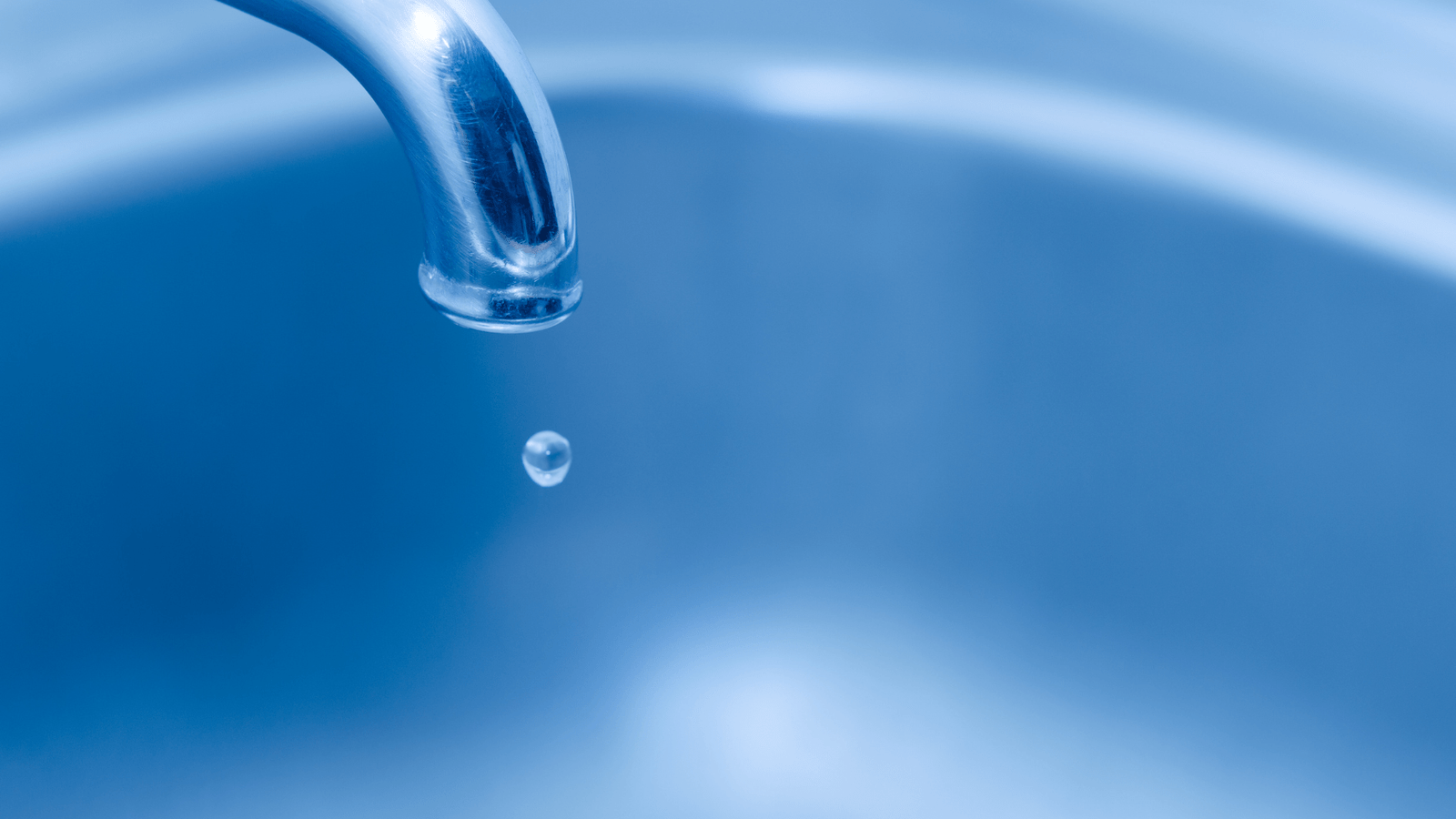 A steady drip of water from a kitchen faucet, highlighting a common household plumbing nuisance.

