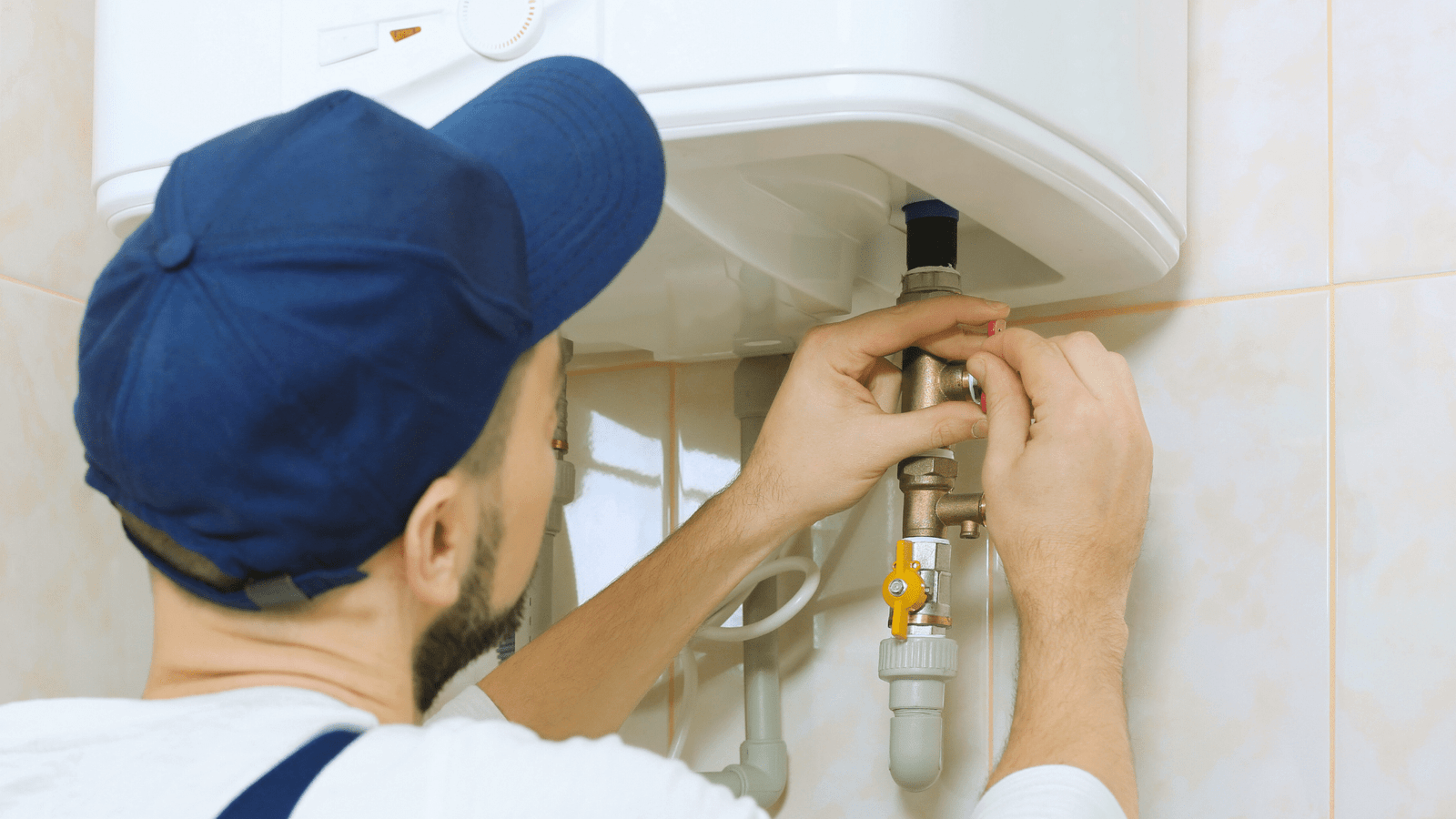 A Tubero Experts plumber inspecting a water heater, ensuring optimal performance and safety.

