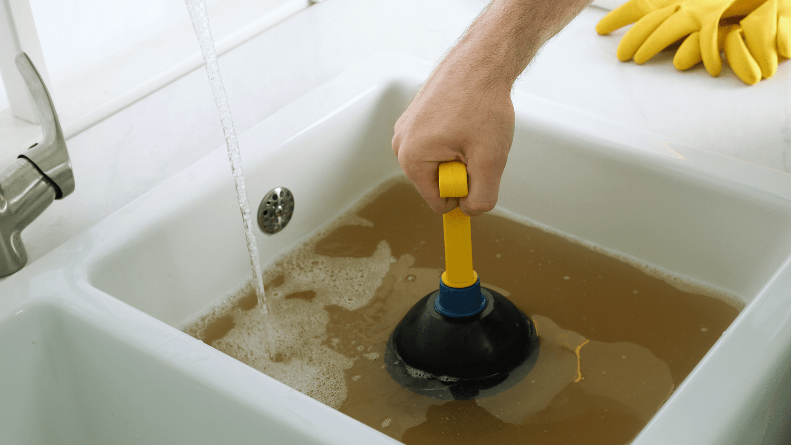 A kitchen sink completely backed up with food particles and standing water, illustrating a common and frustrating clog for a client.