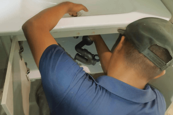 Reliable plumber in Metro Manila working on kitchen sink declogging for commercial client