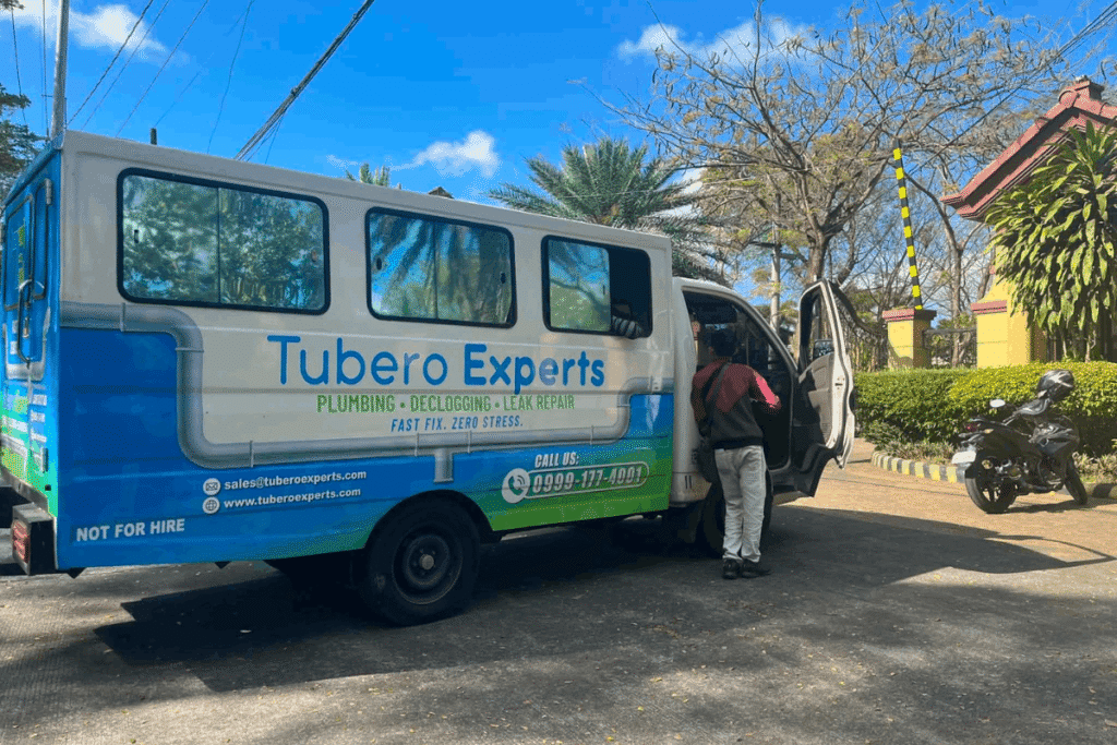 Tubero Experts plumbing, declogging, and leak repair service van at a residential entrance.