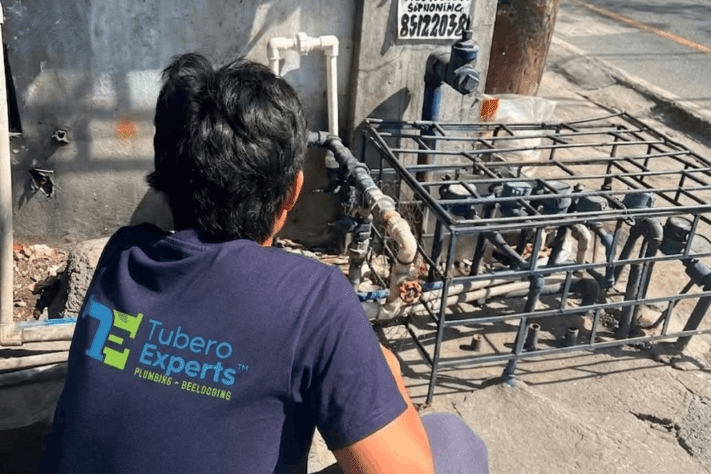 Tubero Experts plumber inspecting a water meter connection for a leak repair.