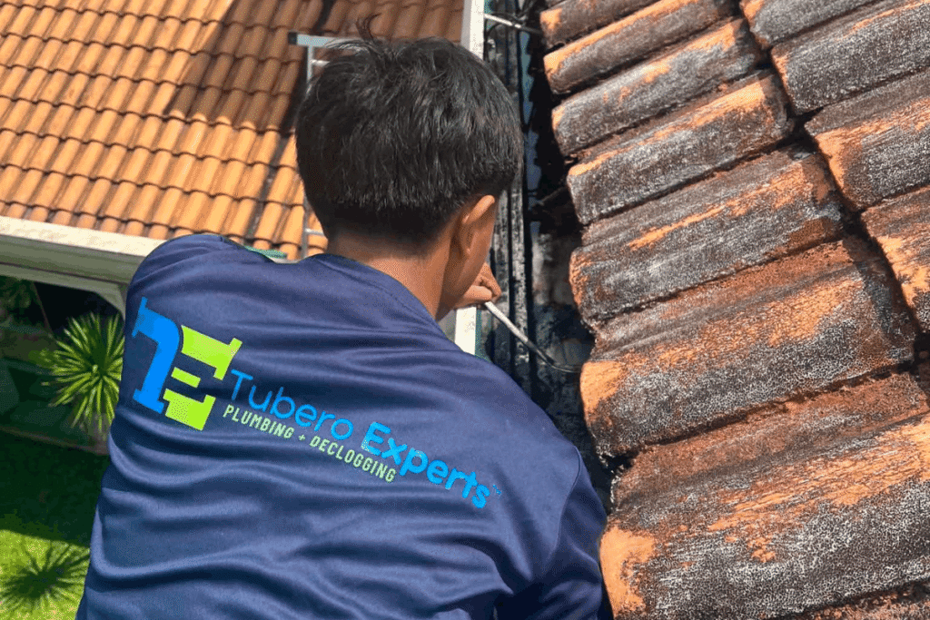 Tubero Experts plumber clearing a roof gutter drain in BGC.