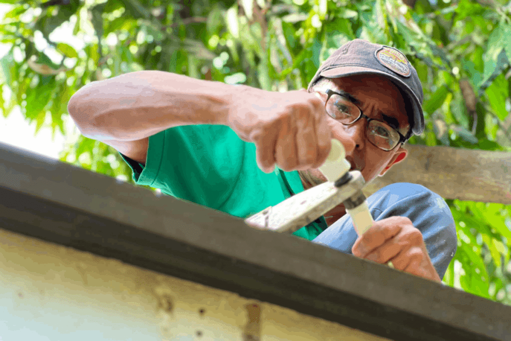 Plumber repairing a water leak on a PVC pipe fitting in Taguig.