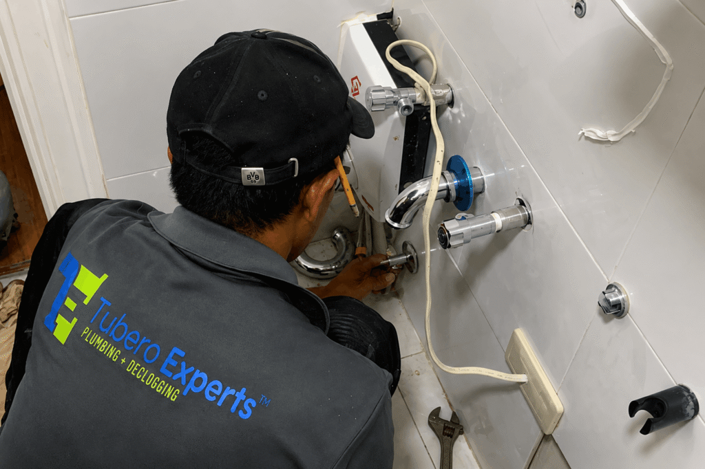 Tubero Experts plumber installing a bidet and faucet fixture on the wall