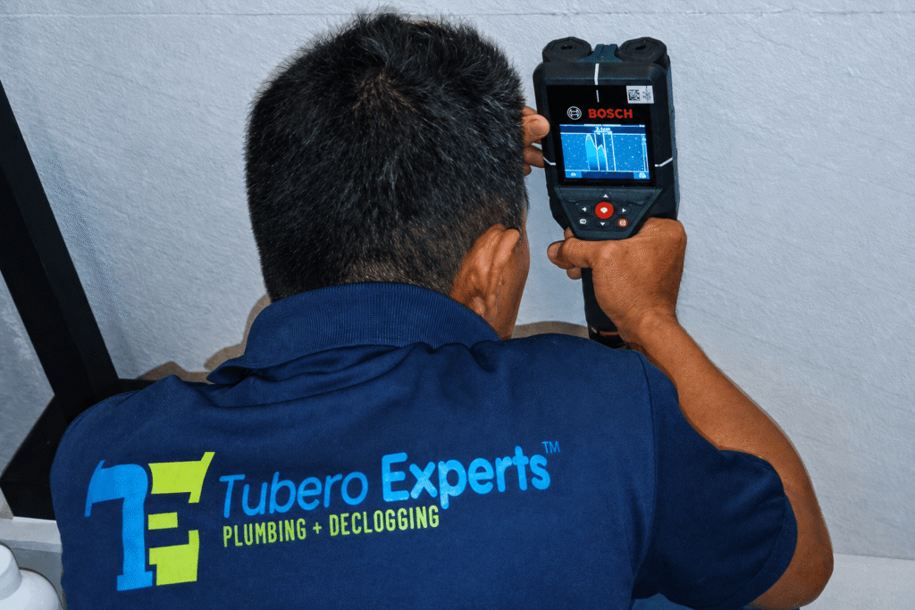 Technician using a leak detector to trace a hidden water leak