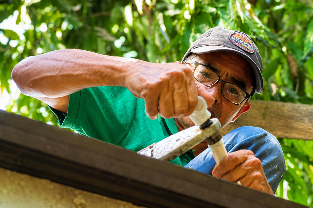 Tubero Experts plumber installing overhead PVC piping as part of a water line repiping job.