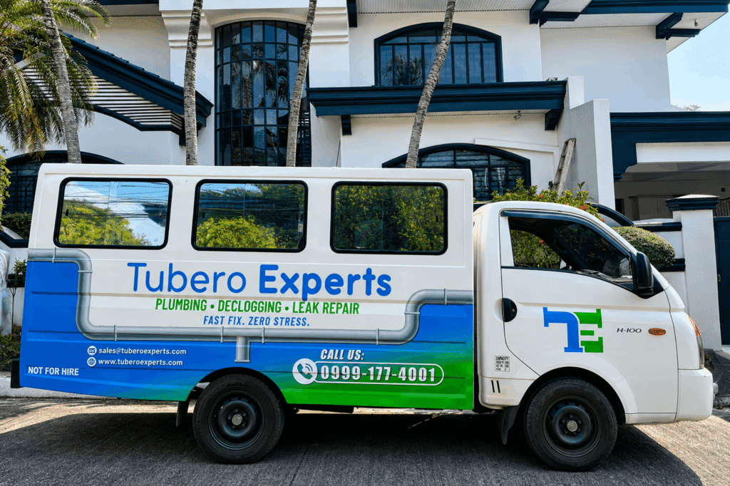 Tubero Experts plumbing, declogging, and leak repair service van parked outside a residential home