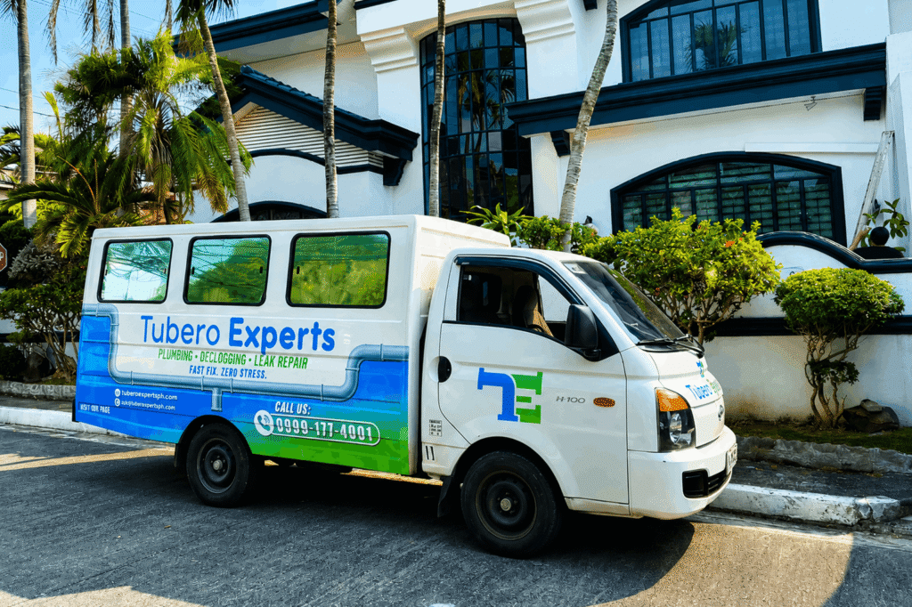 Tubero Experts plumbing and declogging service van parked outside a residential property