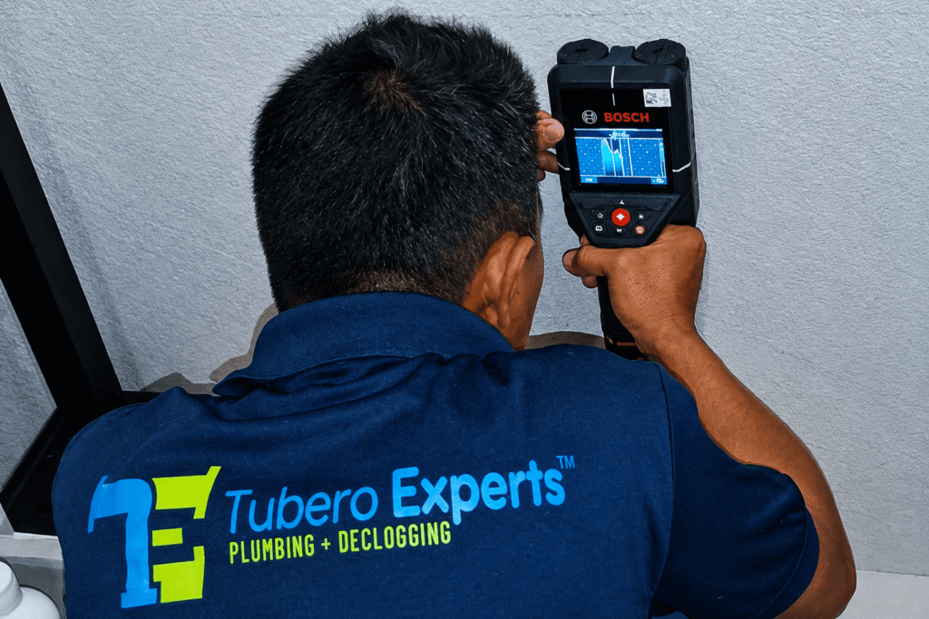 Tubero Experts technician using a Bosch detector for water leak detection on a wall.