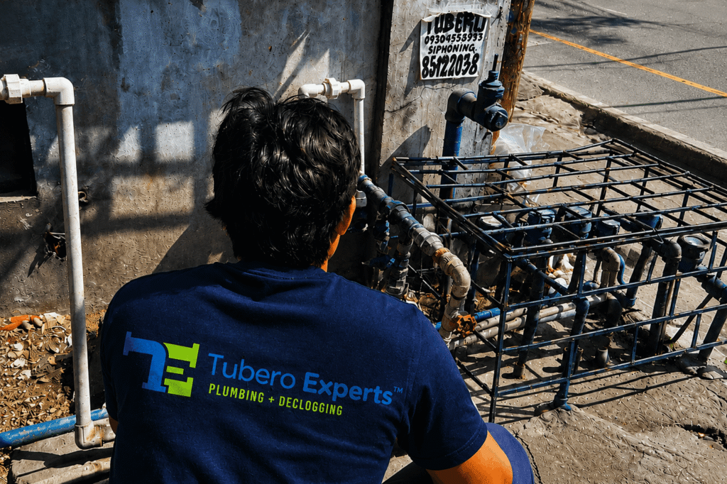 Tubero Experts technician inspecting outdoor water meters and pipes for water leak repair.