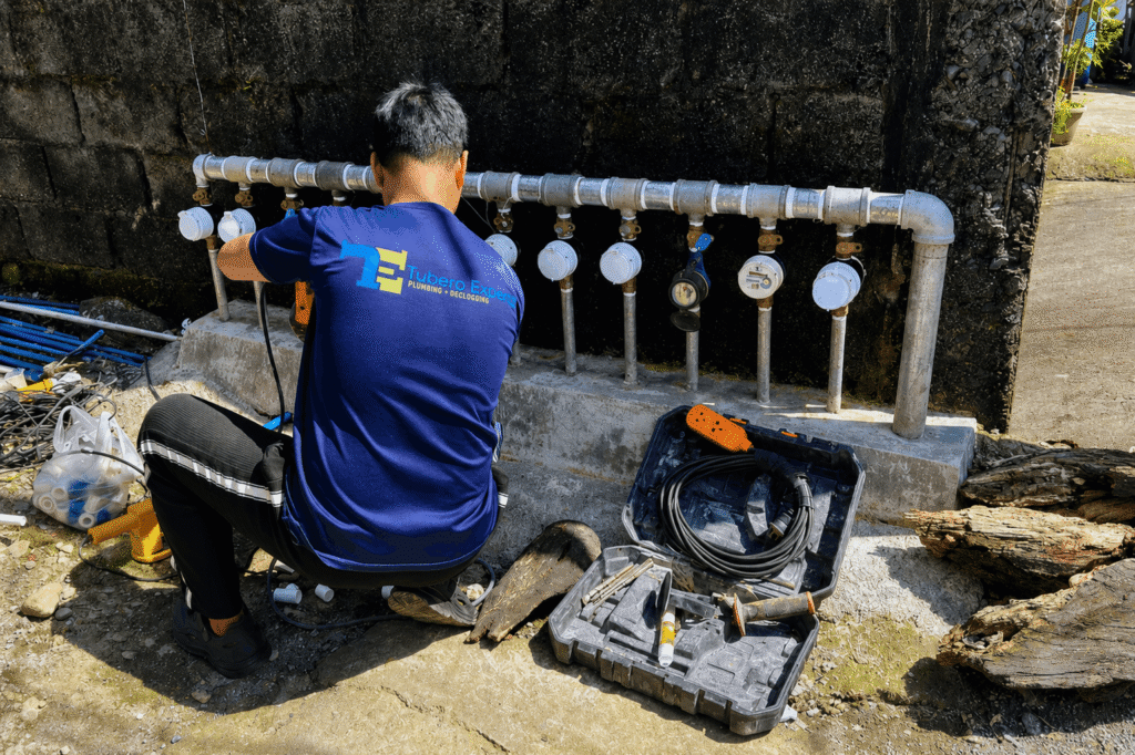 Tubero Experts technician repairing water meters with equipment case during water leak repair.
