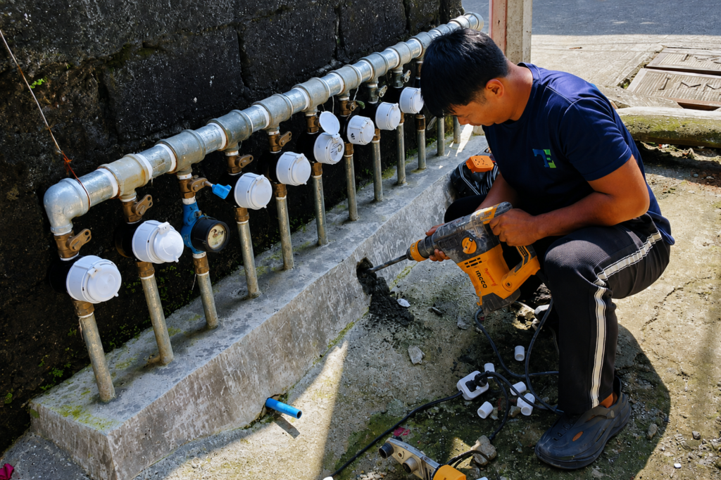 Tubero Experts technician drilling to access underground water line pipes and meters.