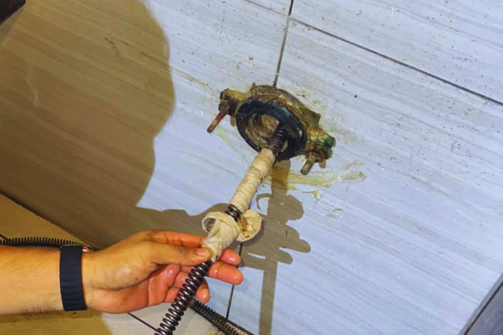 Drain cable pulled out with clogged debris wrapped around it