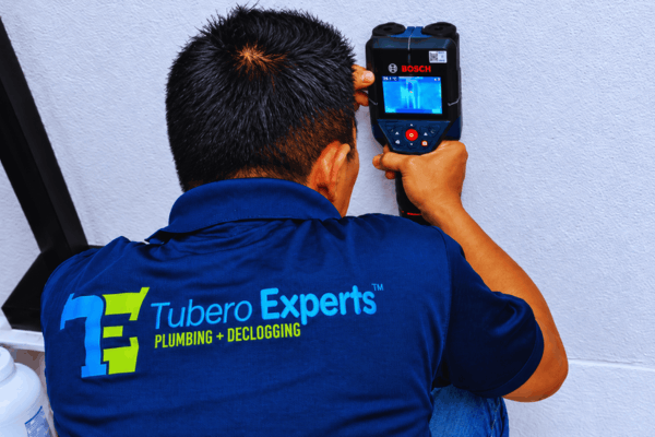 Tubero Experts plumber scanning a wall with a thermal leak detector