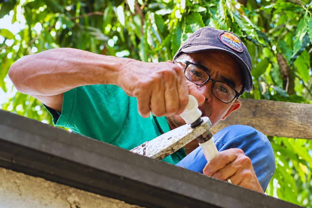 Tubero Experts plumber fitting a white PVC pipe joint on a rooftop water line