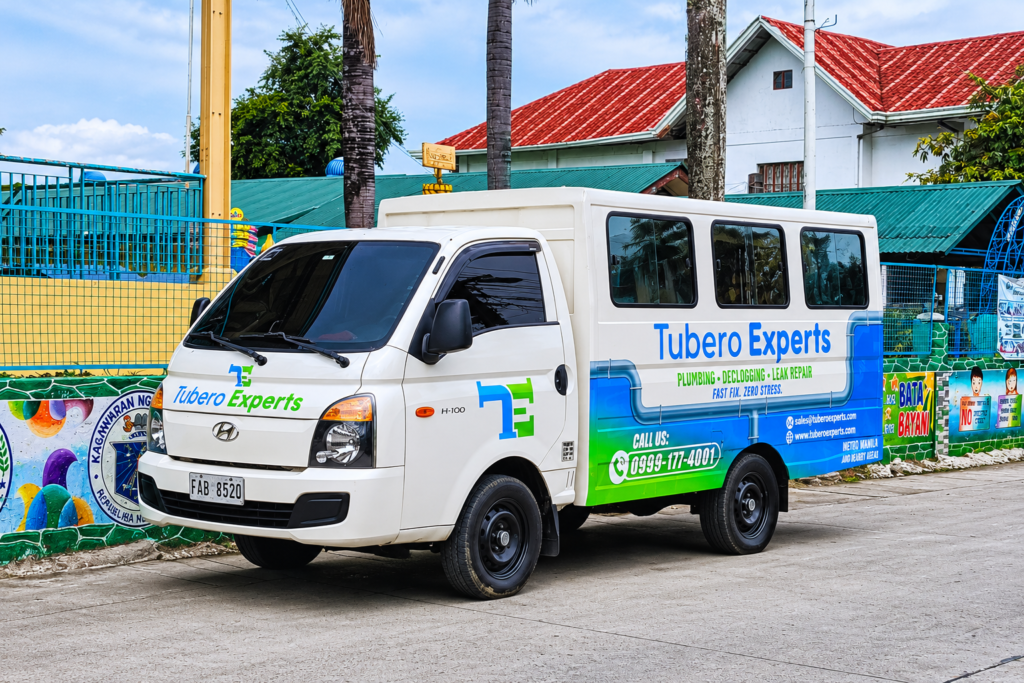 Tubero Experts service van parked on a street outside a building