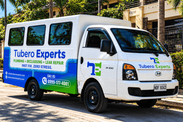 Tubero Experts service van parked along a tree-lined street