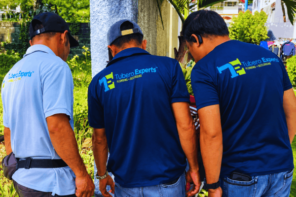 Three Tubero Experts technicians discussing a plumbing issue on site